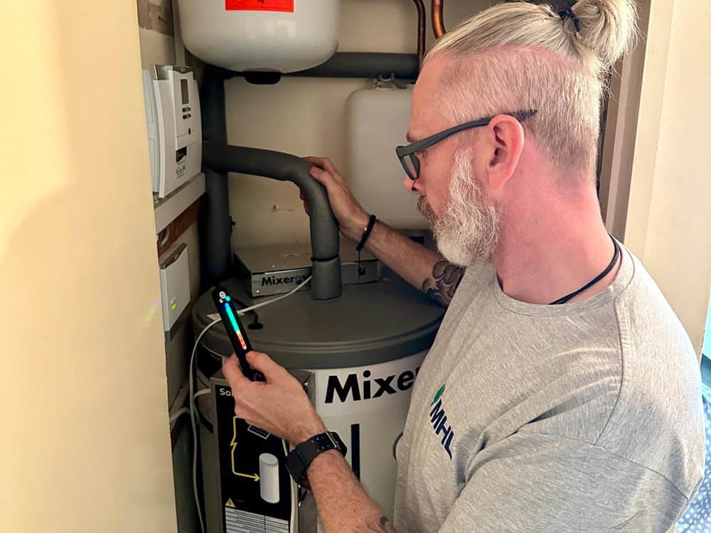 ashp-consultation Engineer inspecting heating equipment in a home